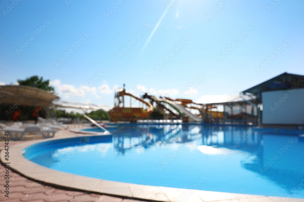 Blurred view of water park with swimming pool. Summer vacation