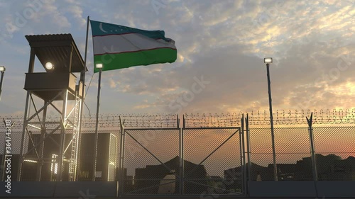 Waving flag of Uzbekistan above military base in the evening photo