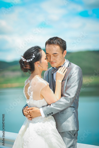 Prtrait of Asian bride and groom with beautiful landscape of dam and mountain photo