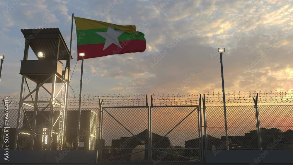 Waving flag of Myanmar above military base in the evening