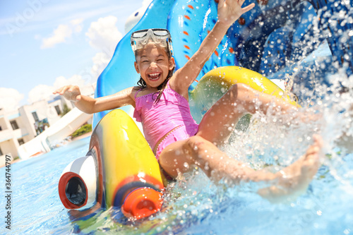 Fotografía Little girl on slide at water park. Summer vacation