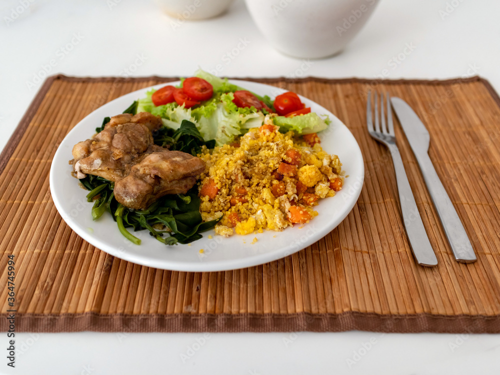 White crockery dish, with lettuce, tomato, broccoli, Moroccan couscous and oven-roasted chicken file, on straw base on white table, Rio de Janeiro, Brazil White crockery dish, with lettuce, tomato, broccoli, Moroccan couscous and oven-roasted chicken file, on straw base on white table, Rio de Janeiro, Brazil
