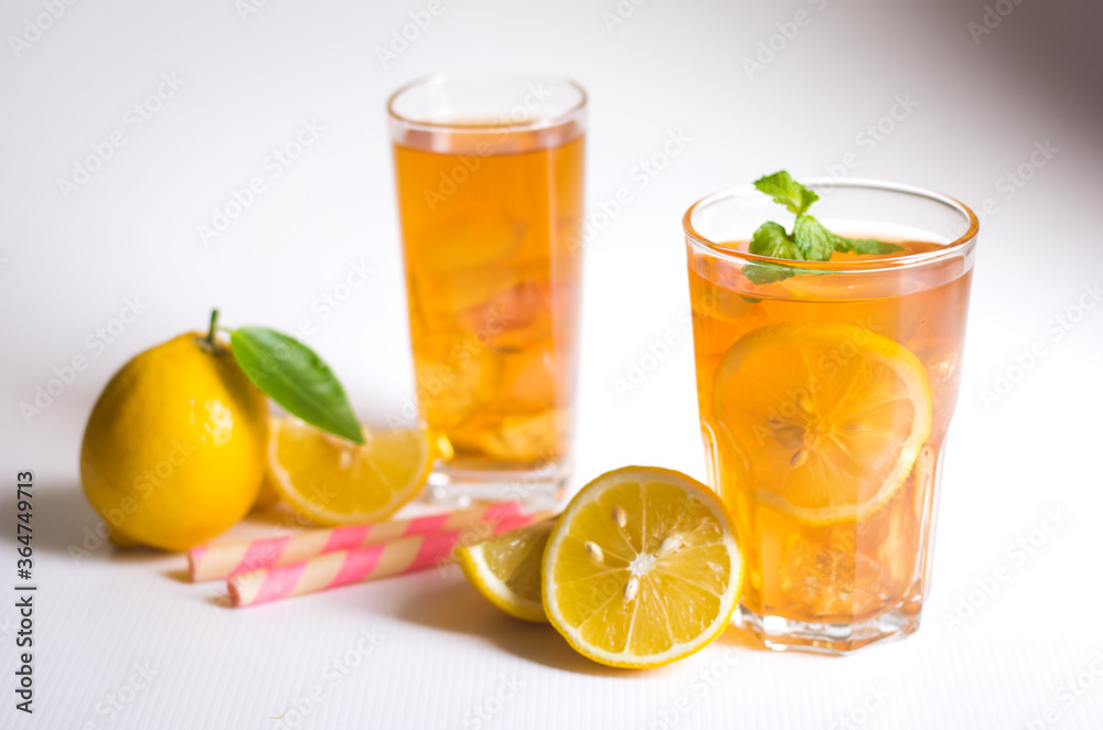 Glasses of ice tea with lemon slices and mint on white background Glasses of ice tea with lemon slices and mint on white background