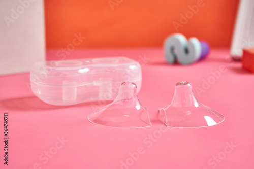Two nipple covers on a pink background
