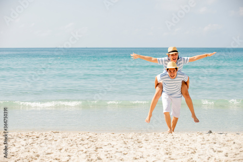 Happy asian couple enjoy together on the beach