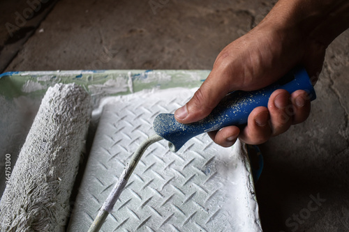 Foto Hand of a house painter with a paint roller