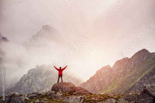 Hiker with backpack standing on top of a mountain with raised hands. Slovakia  Europe.