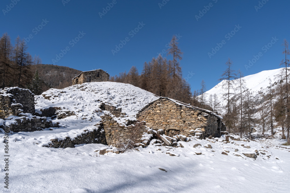 Ruins of stone buildings in winter mountains