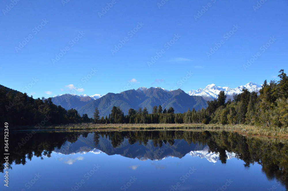 Fototapeta premium Lake Matheson, near the Fox Glacier in South Westland, New Zealand, is famous for its reflected views of Aoraki/Mount Cook and Mount Tasman.