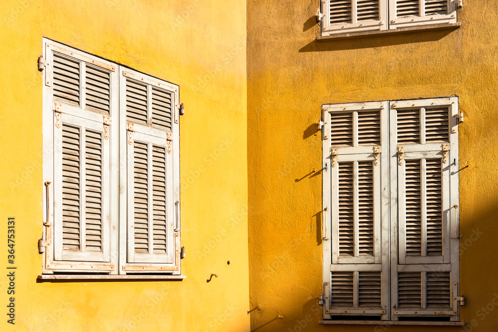 Mur d'une maison colorée de Nice aux volets clos