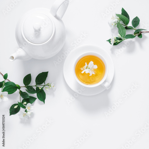 Jasmine flowers and teapot on white background. Herbal tea of jasmine flower. Jasmine tea concept. Flat lay  top view  copy space