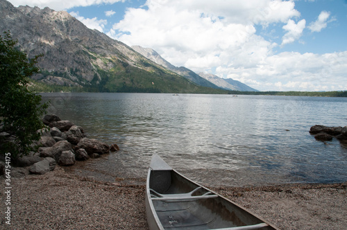 A canoe sits on beach ready to be launched onto Lake Jenny in Grand Teton National Park, Montana, USA