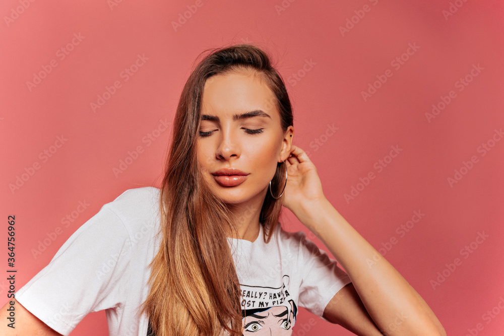 Close up fashion portrait of trendy pretty woman with long golden hair posing with wonderful smile and closed eyes over pink background Close up fashion portrait of trendy pretty woman with long golden hair posing with wonderful smile and closed eyes over pink background