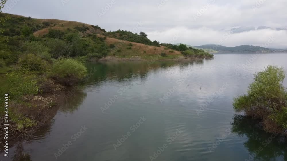 Drone view of lake in fog, mountain and island Drone view of lake in fog, mountain and island