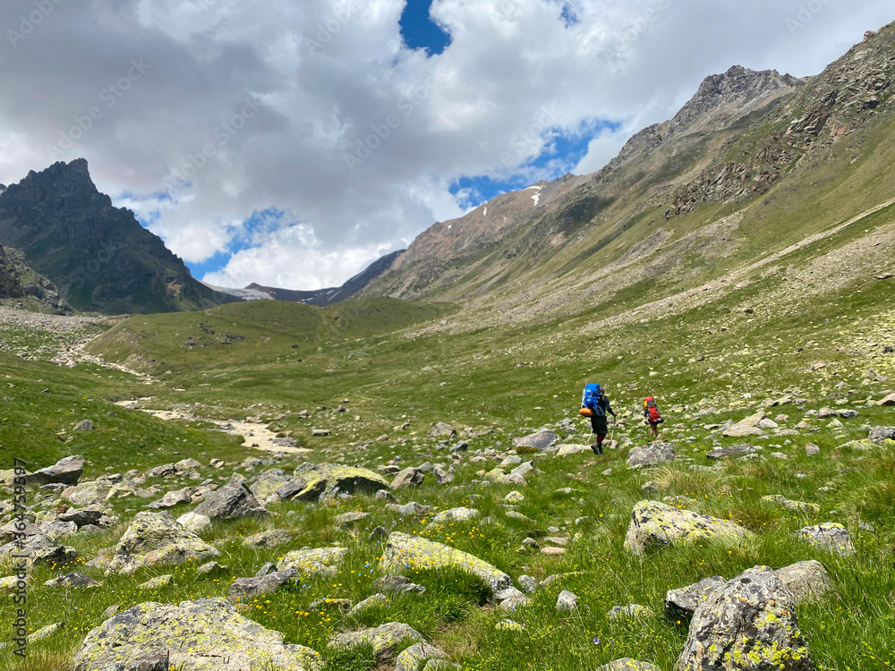 Two climbers are walking along a mountain trail.