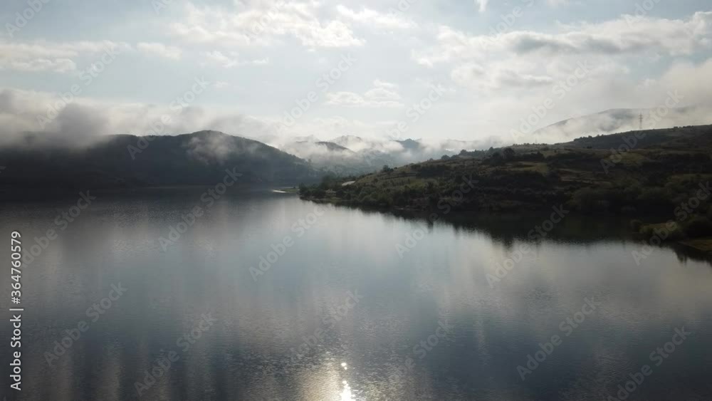 Drone view of lake in fog, mountain and island