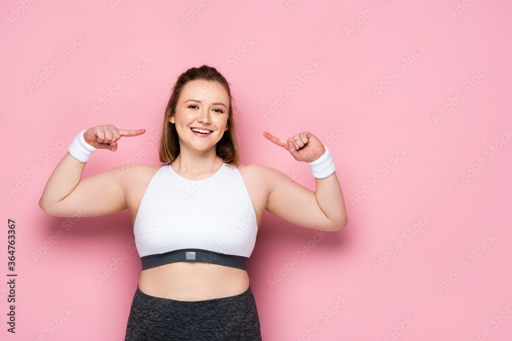 happy overweight girl pointing with fingers at herself on pink happy overweight girl pointing with fingers at herself on pink