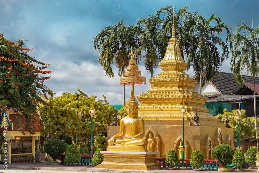 golden buddha image statue with pagoda in south of Thailand