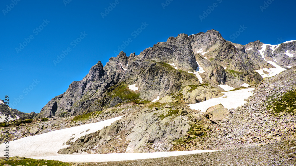 French Alps with snow in summer near Chamonix, panoramic view. Savoy tourism. Mountain trekking. Global warming, melting of snow French Alps with snow in summer near Chamonix, panoramic view. Savoy tourism. Mountain trekking. Global warming, melting of snow
