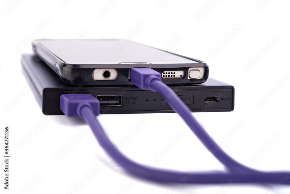 smartphone mobile charging by power bank with purple or violet usb cable isolated on white background. smartphone mobile charging by power bank with purple or violet usb cable isolated on white background.