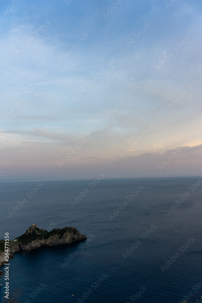 Fototapeta premium vertical shot of coastline and sea at sunset