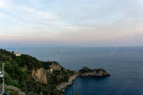 coastline surrounded by sea at sunset