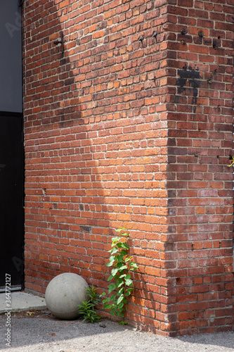 Corner of a brick wall with large cement ball