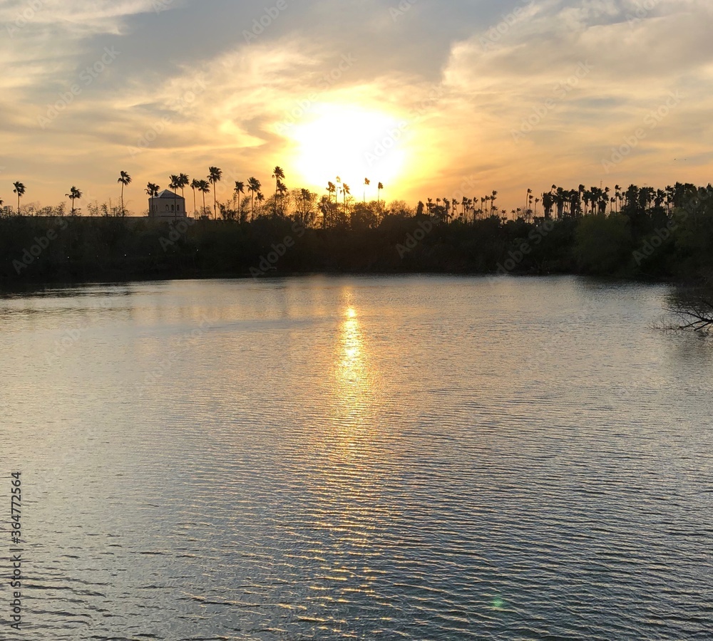 Fototapeta premium Sunset on the horizon observed by a lake