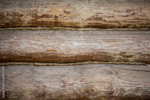 Wooden wall from old round logs. Background rustic texture