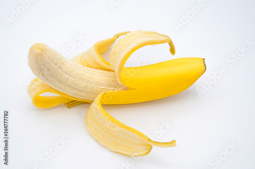 Tasty peeled banana fruit over white background