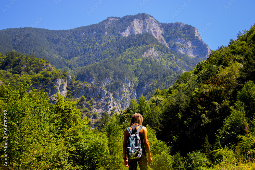 girl with her back turned in front of the mountain