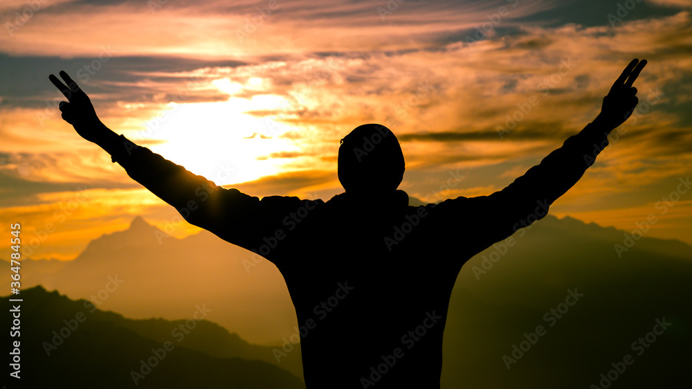 Happy man silhouette with arms raised in success on sunrise glow sunshine banner panorama. Wellness, financial freedom, healthy life concept background.