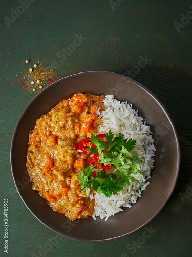 Chicken tikka masala spicy curry meat food in marbre plate with rice and spices on dark gray background. photo