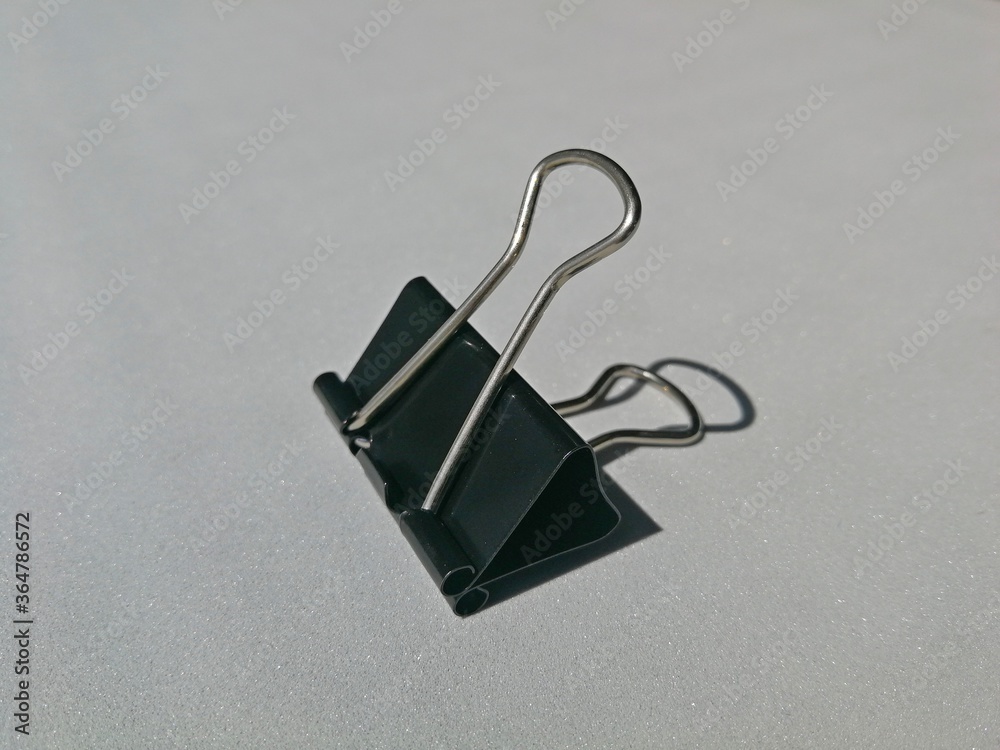 Flexible steel office paper clip, placed in a gray place Flexible steel office paper clip, placed in a gray place