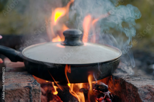 Grilled minced meat sausages, lie in a pan near the fire