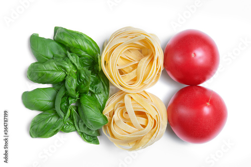 Basil leaves, pasta, tomatoes on a white isolated background. Colors of the flag of Italy. Fresh herbs, spices. Copy space.
