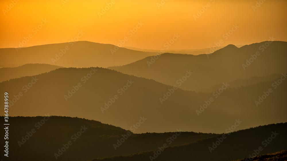 Silhouettes of mountains against the backdrop of the setting sun. Wielka Rawka Mountain. The Bieszczady Mountains, Carpathians. Poland