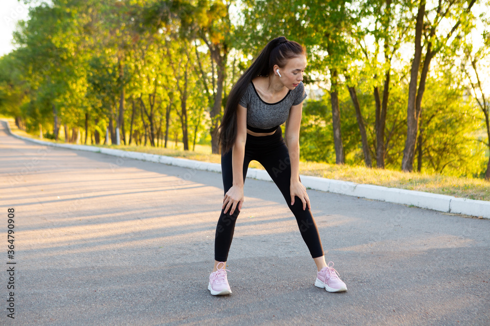 Fitness woman tired jogger breathing after run marathon in park. Fitness woman tired jogger breathing after run marathon in park.
