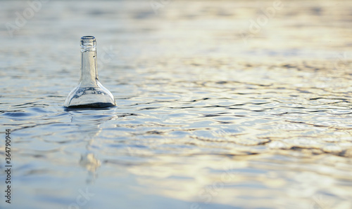 glass bottle floats adrift in water