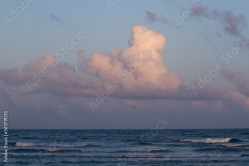 The ocean at sunset. Seascape. Clouds over the sea waves with beautiful golden hour colors. 