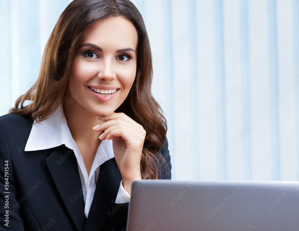 Portrait image of happy smiling beautiful businesswoman in confident style suit using laptop computer at office. Success in business, job and education concept. Portrait image of happy smiling beautiful businesswoman in confident style suit using laptop computer at office. Success in business, job and education concept.