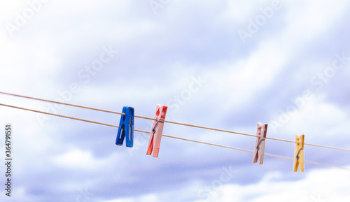 colorful clothespins on a rope against the sky