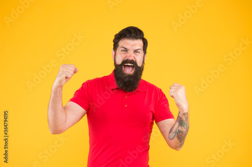 Inner energy. Motivated for success. Happy man show success gesture yellow background. Victory and success. Bearded man in casual style celebrating. Happiness and joy. Winner and victory. Joyful guy