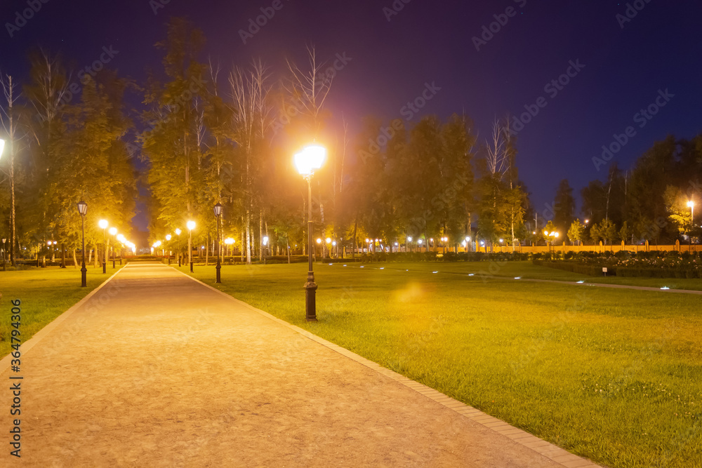 evening park, along the track burning lanterns, next to the green lawn evening park, along the track burning lanterns, next to the green lawn