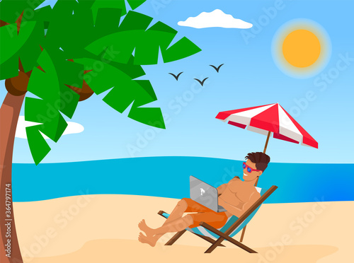 Young stylish guy lying on chair at beach near sea or ocean. Man wearing sunglasses relaxing under umbrella and using laptop. Work at distance, work remotely, freelance, online work in internet