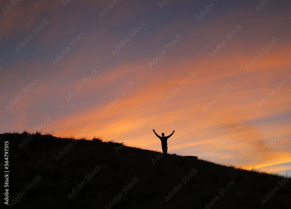 silhouette of a man jumping on a sunset