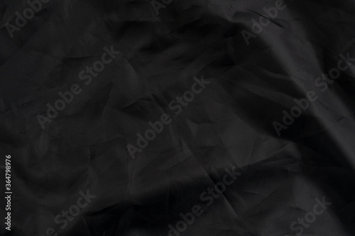 Wrapping black material with wrinkles and wrinkled folds
