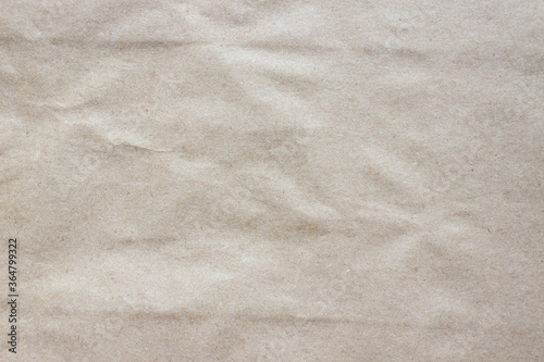 Brown rough crumpled recycled paper texture. Kraft paper background.