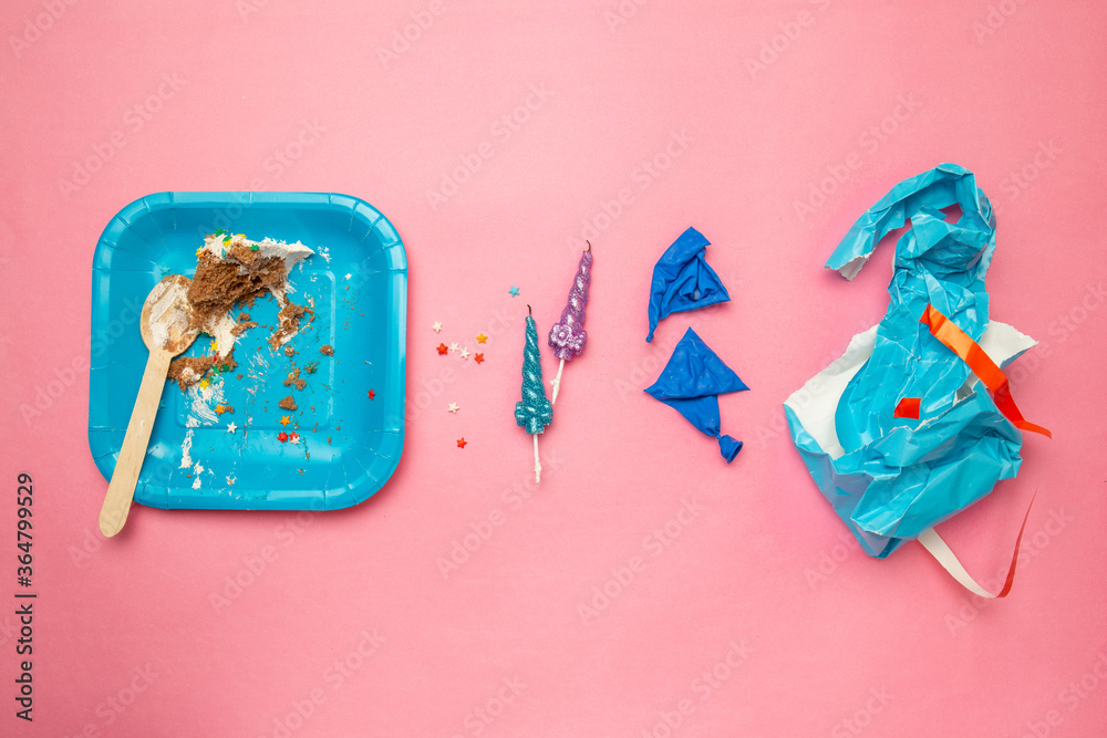 Flat lay of Celebration. After party concept. Half eaten cake, burst ball, gift wrapping paper, burnt candles