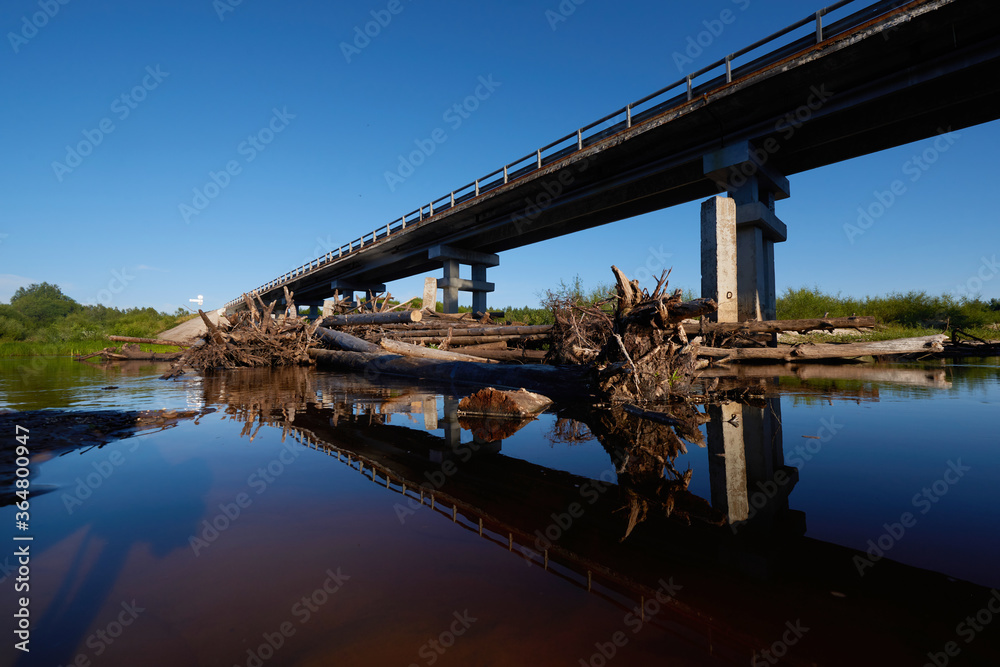 Modern road bridge over the river, bottom view from the water.